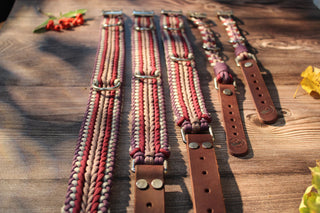 Paracord-Hundehalsbänder Ljus und Tjock in Berry mit Fettlederriemen, im Größenvergleich auf Holz.