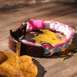 Paracord-Hundehalsband Ljus in Pink, mit braunem Fettlederriemen und Metallring auf Holz.