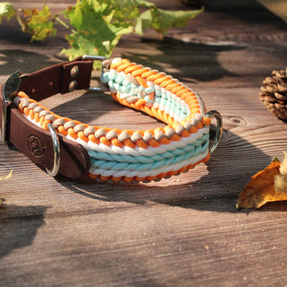 Paracord-Hundehalsband Tjock in Orange, mit braunem Fettlederriemen und Metallring auf Holz.