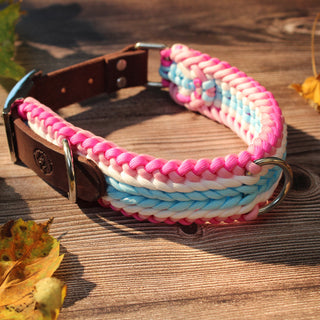 Paracord-Hundehalsband Tjock in Pink, mit braunem Fettlederriemen und Metallring auf Holz.