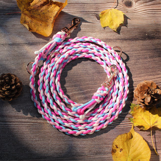 Paracord-Hundeleine Ljus in Pink, aufgerollt auf Holz, mit Karabinern und Ringen.