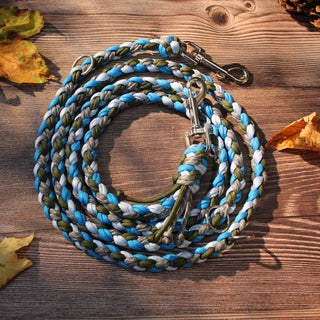 Paracord-Hundeleine Tjock in Blau, aufgerollt auf Holz, mit Karabinern und Ringen.
