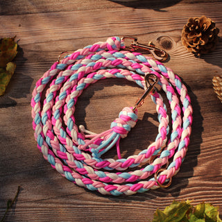 Paracord-Hundeleine Tjock in Pink, aufgerollt auf Holz, mit Karabinern und Ringen.